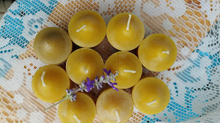 a set of beeswax candles with small purple flower